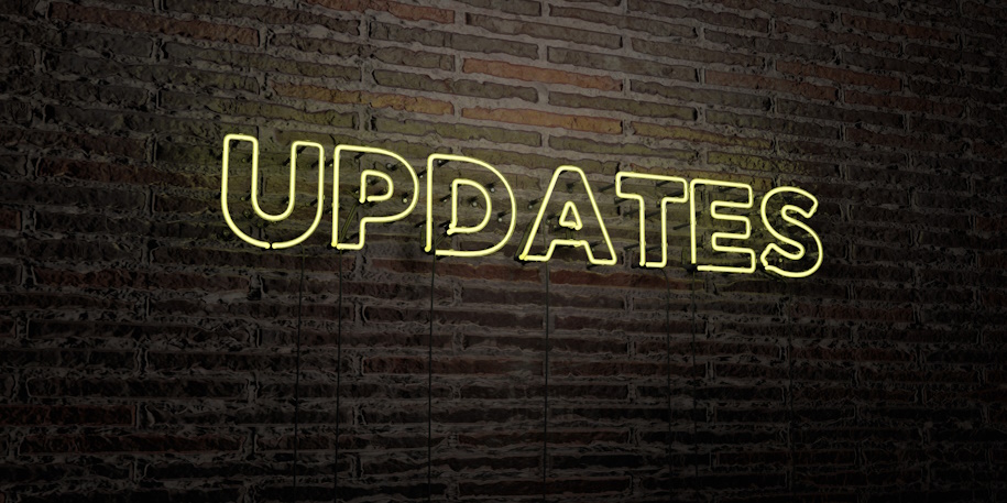 brick wall with a neon updates sign